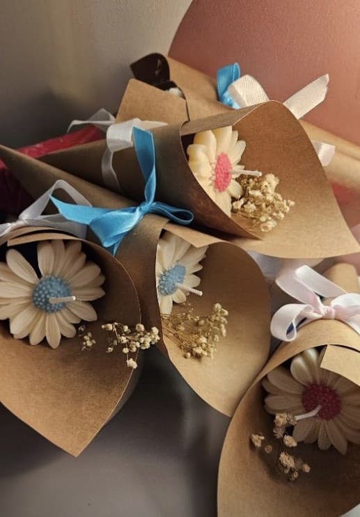 Small bouquets of dried daisies wrapped in kraft paper with ribbon