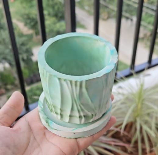 Green and white marbled resin planter held in a hand